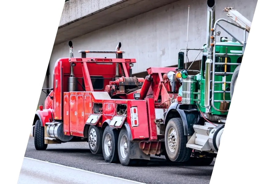 A truck with a tow truck on the side of the road.